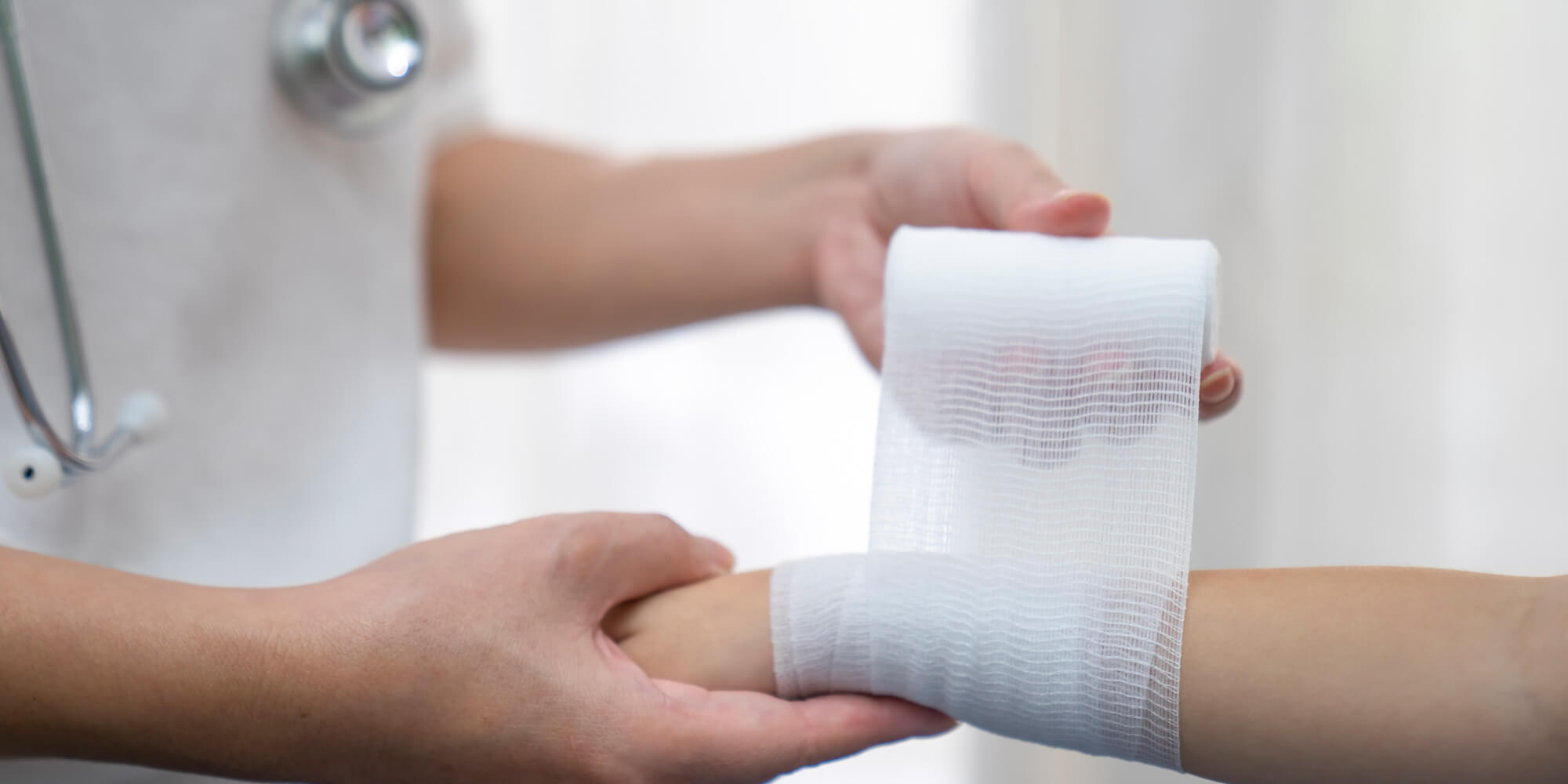 Medical professional wrapping a bandage around a patient's wrist