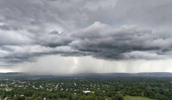 Photo of a thunderstorm rolling across a pollinated field