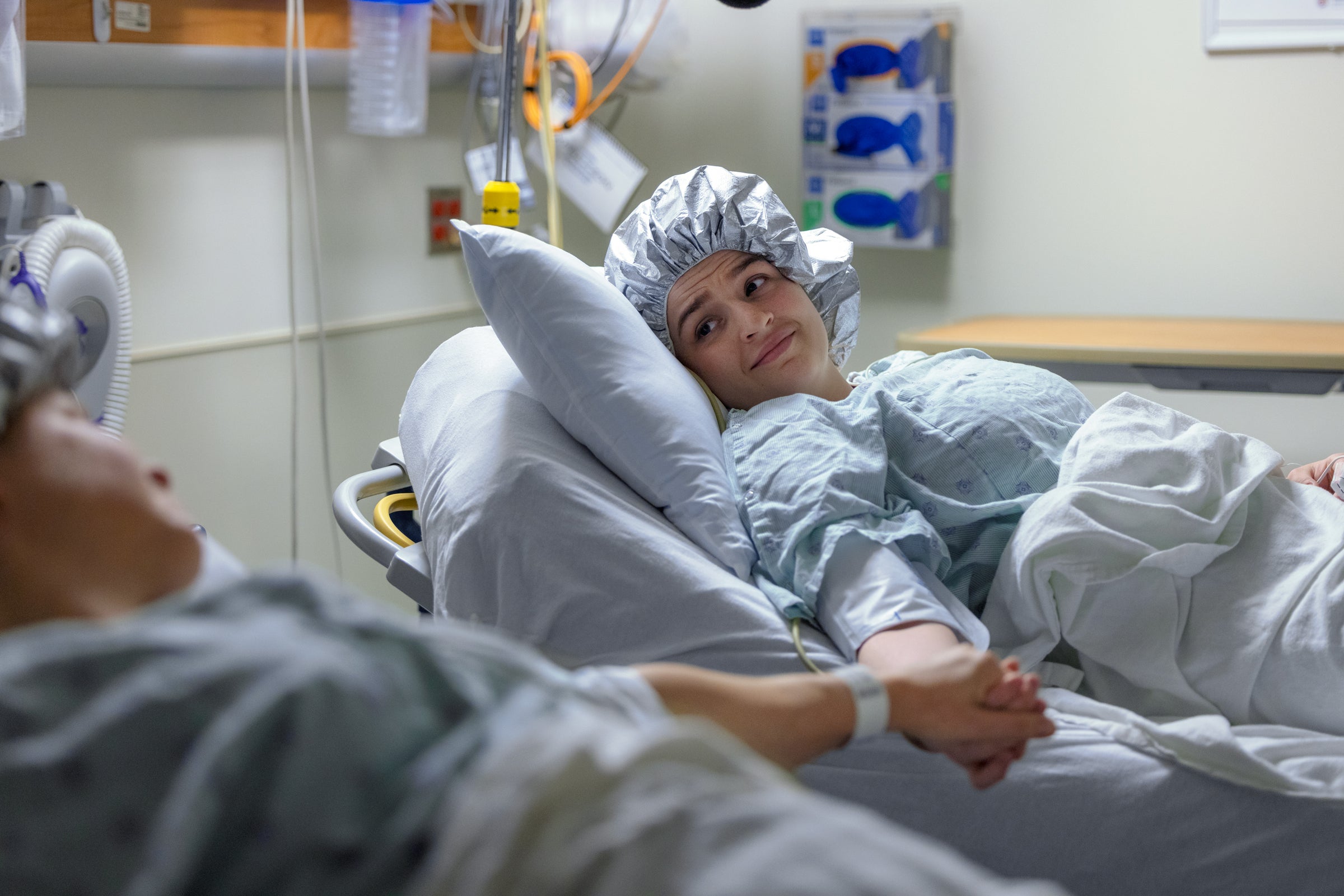 Transplant patient and organ donor hold hands before surgery.