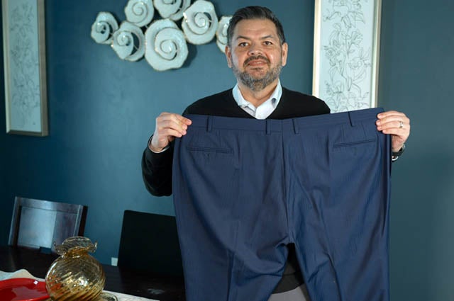 Man holding up large sized pants