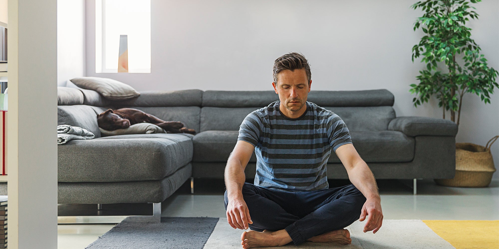 Man in living room practicing breathing exercise