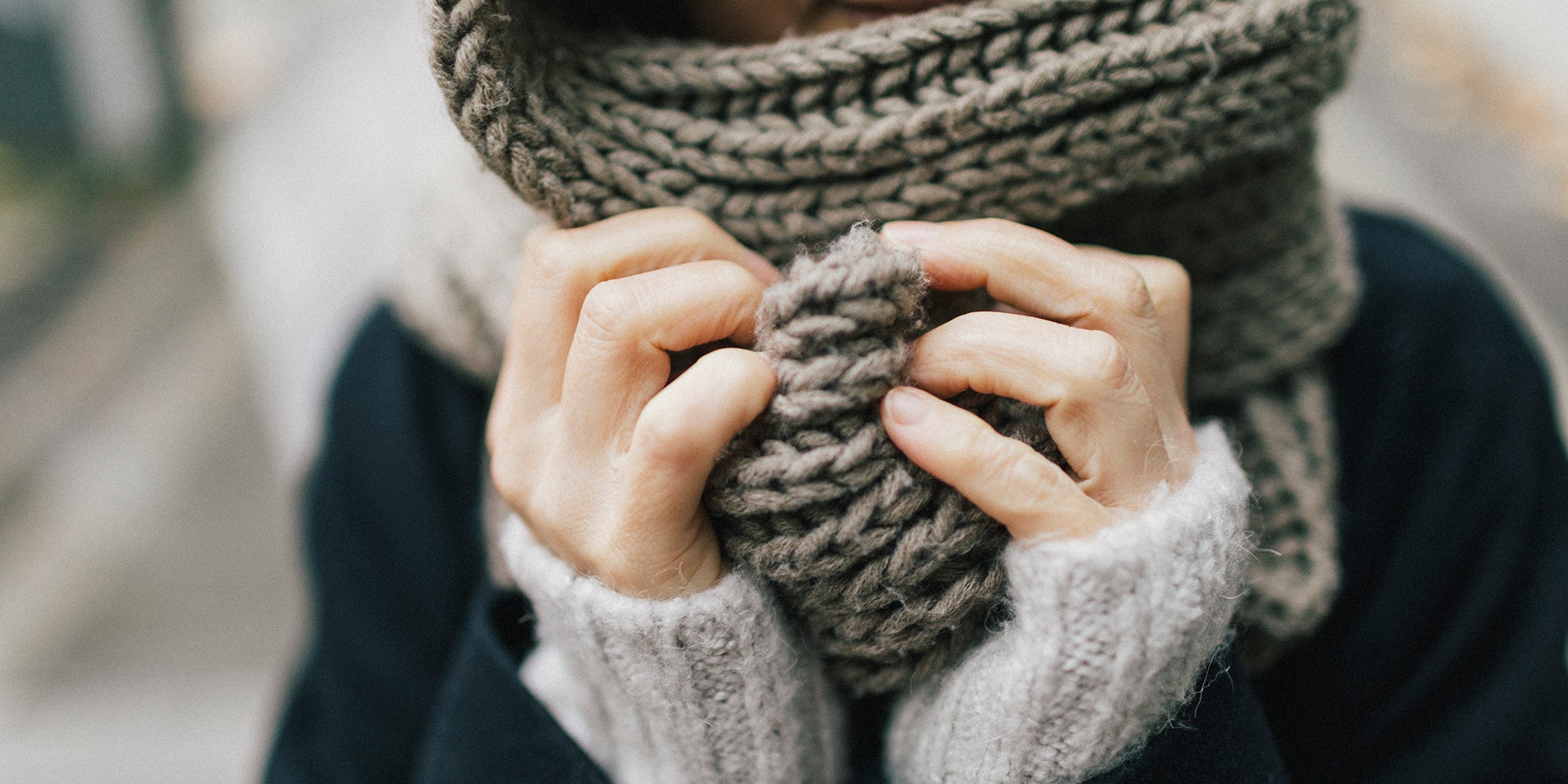 Cold person holding scarf