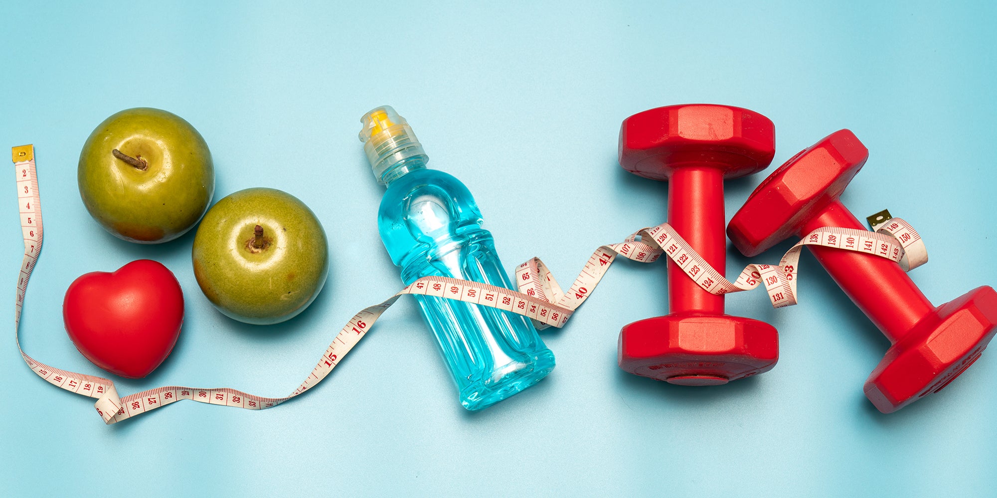 Healthy foods, dumbbell weights and measuring tape