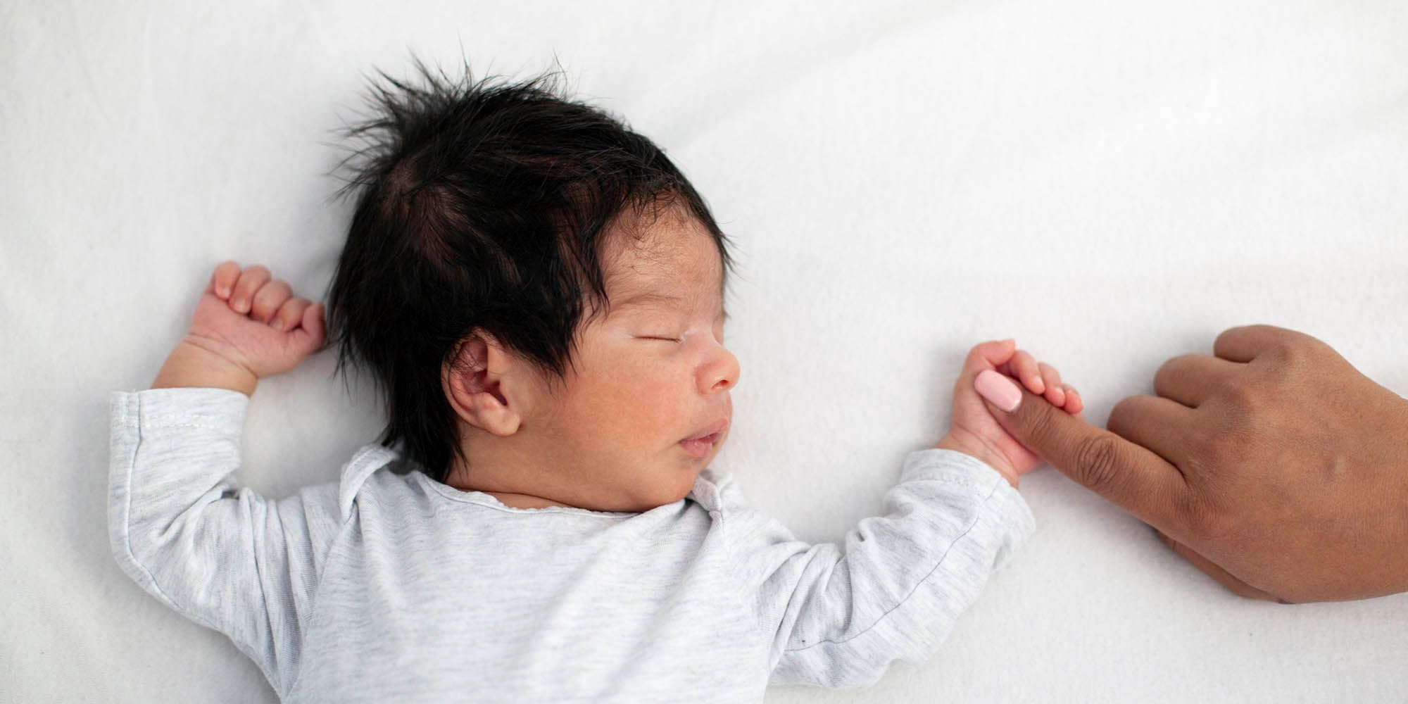 Baby holding mother's finger