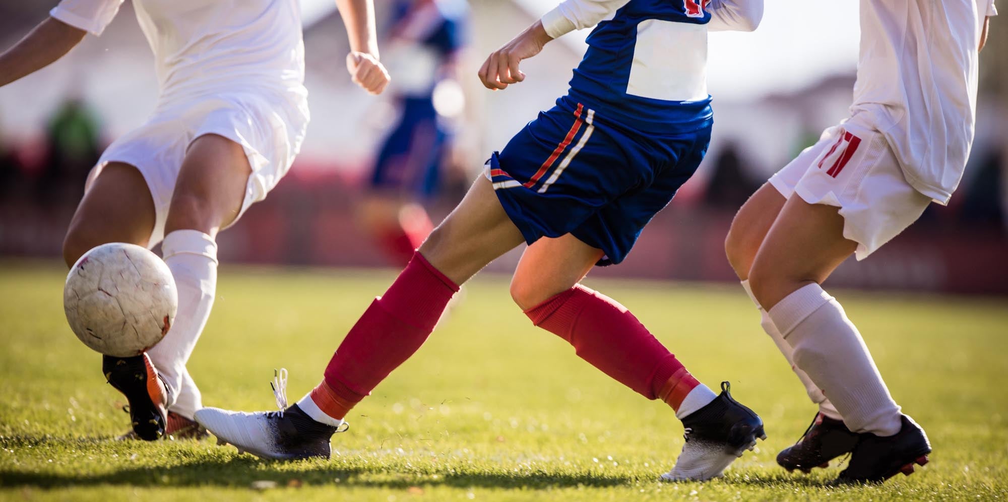 Soccer players kicking the ball