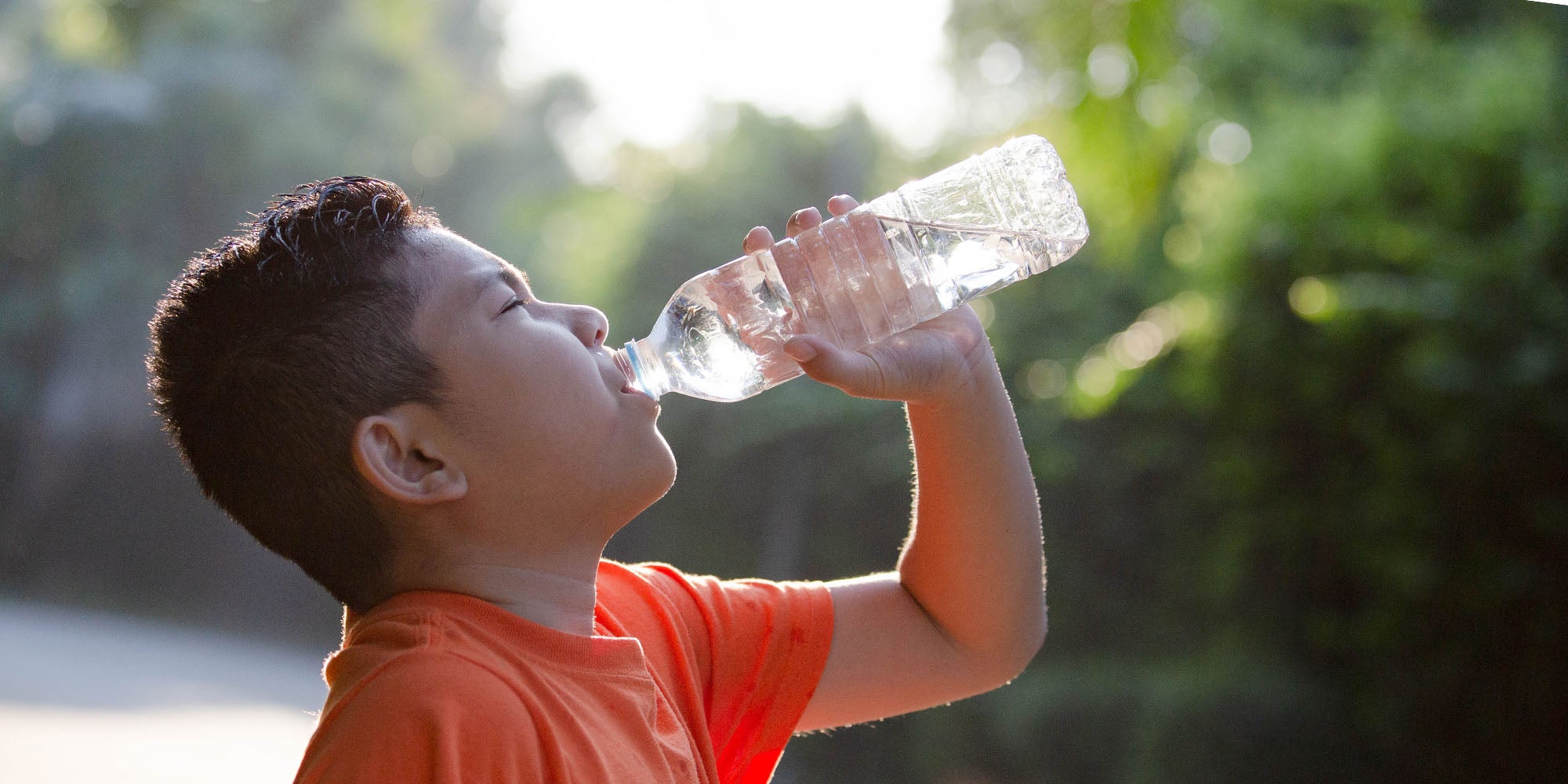 Child drinking water outside