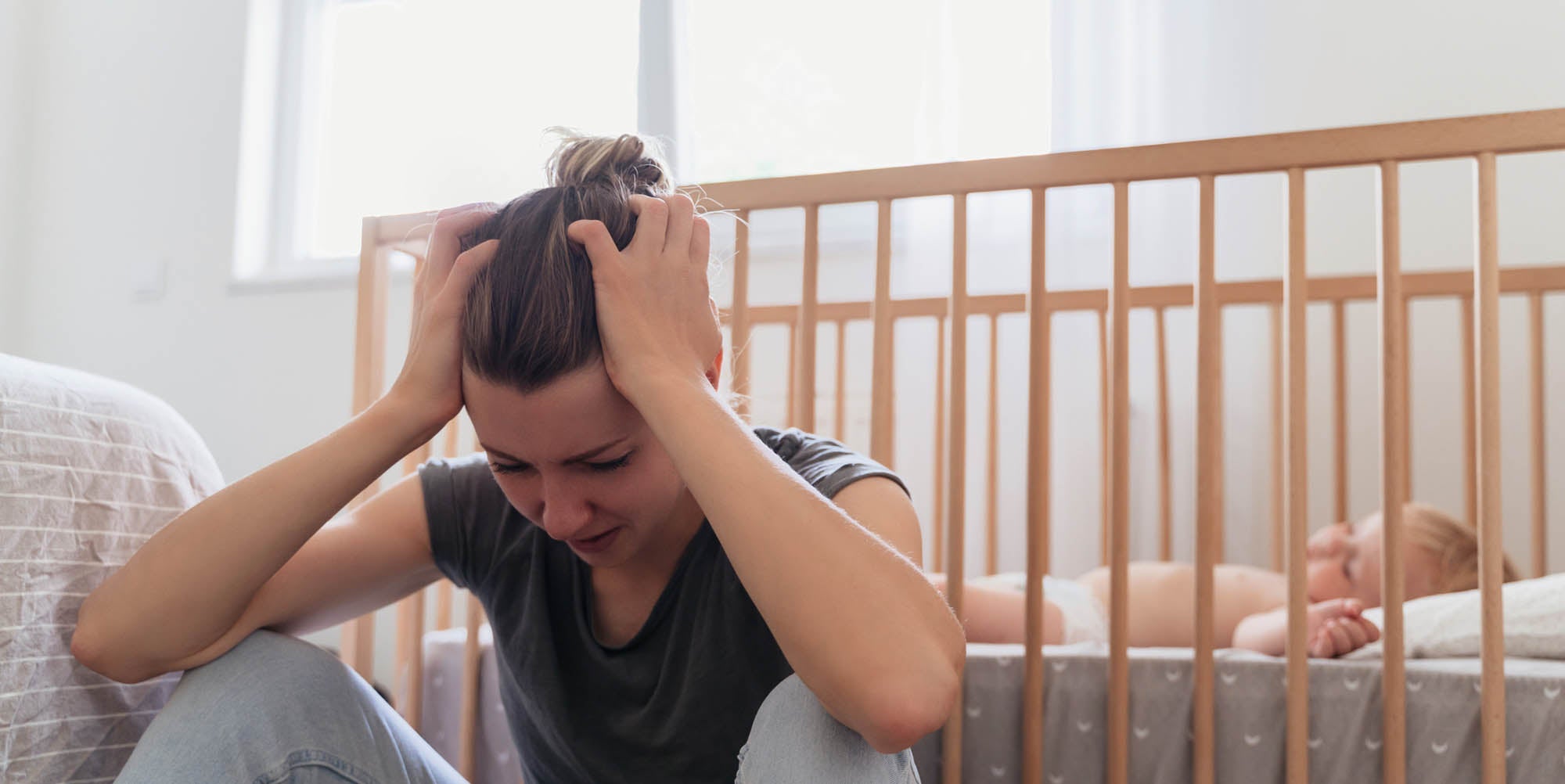 Mother sitting on bed stressed out