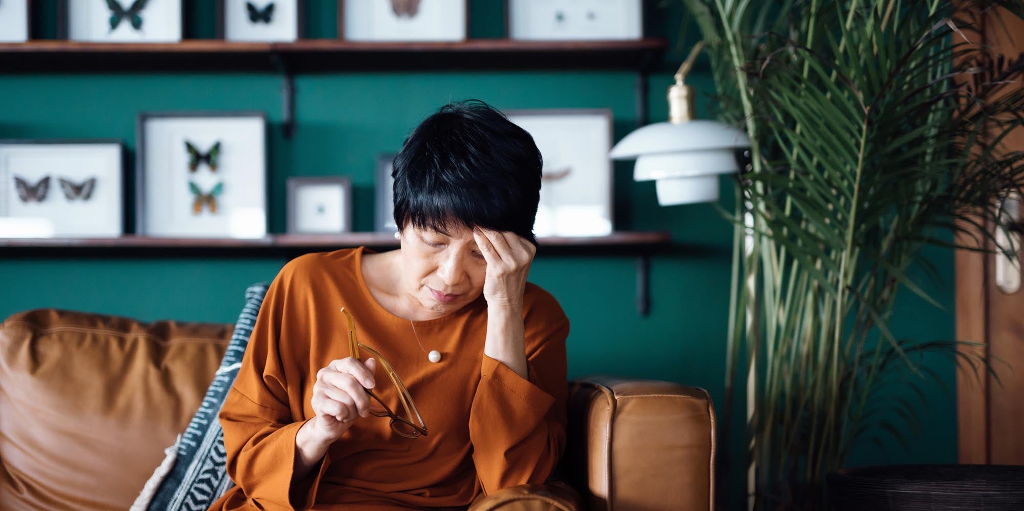 Woman with pain sitting on couch