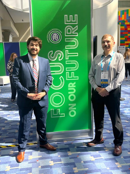 standing in front of banner