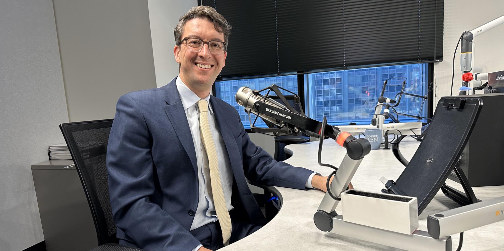 Dejan Micic, MD at a desk on a podcast