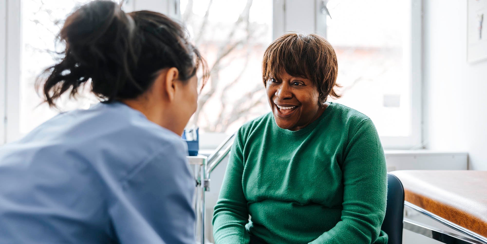Doctor and patient holding hands talking